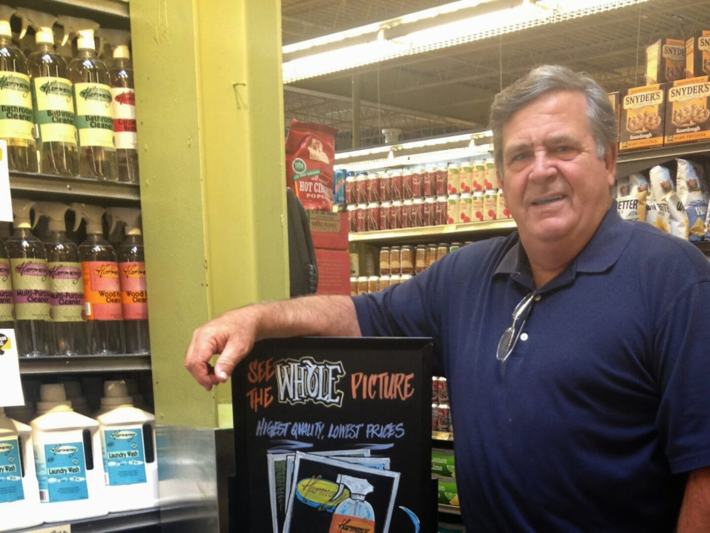 A man standing next to a sign in a store.